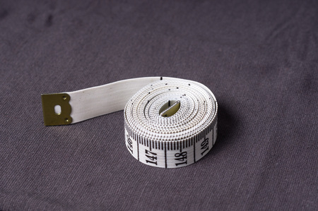 inch, centimeter tape on a background of grey fabricの写真素材