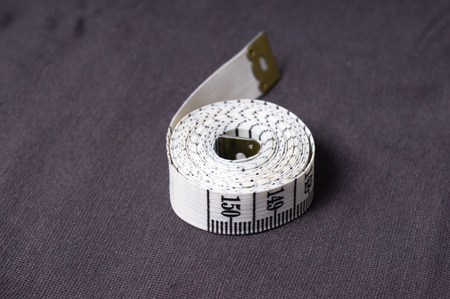inch, centimeter tape on a background of grey fabricの写真素材