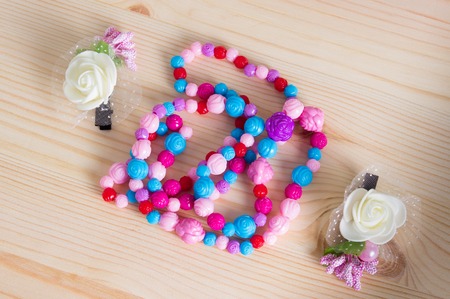 Colorful hair comb crest brushes with handle, bright beads on woden background. Mininmalistic feminine flat lay.の写真素材