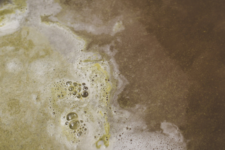 The boiling surface of the beer after laying the green pressed hop. Craft beer brewing from grain barley pale maltの写真素材