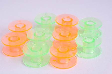 Multicolored plastic bobbin for sewing machine
 layed in rows in 
white background
