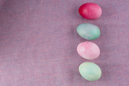 four multicolored painted Easter eggs lilac tablecloth. holiday easter greeting card, poster, wallpaperの写真素材