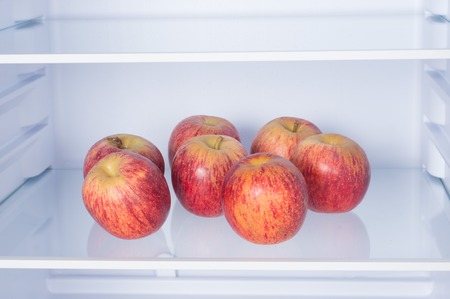 Open fridge, apples on the shelf of refrigerator, healthy nutrition conceptの写真素材