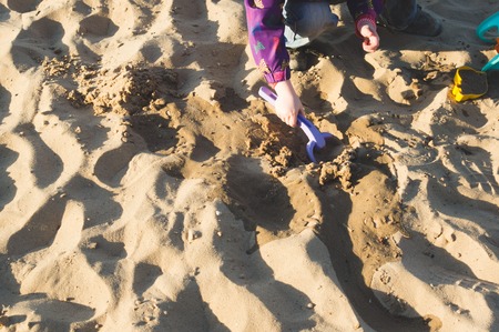 A child playing in the sand on beach. Evening lightingの写真素材
