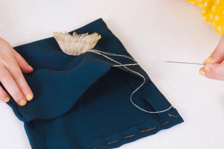 baby hands with a needle, busy sewing a flower to a green clothchildren's creativity and learning...