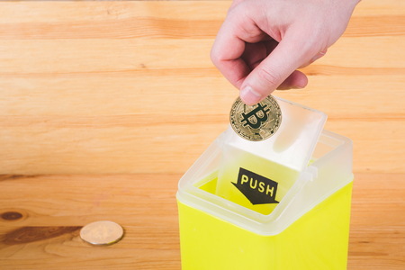 Menâs hand throwing bitcoins in the trash. Concept of cryptocurrency market crisis. blockchain technology.の写真素材