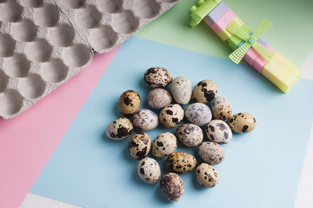 heap of quail eggs and  toy on color background. Vegetarian organic  eco food.