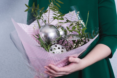 The woman hold bouquet of flowers and kitchen utensils. concept of sexism, feminism and patriarchal society and gender inequalityの写真素材