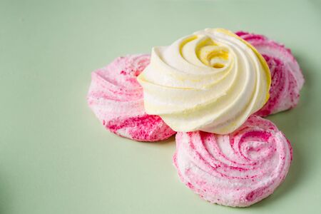 Homemade sweet colored meringue on white background.  
Dessert.