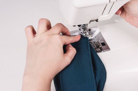 Woman hands using the sewing machine to sew the face mask during
the coronavirus pandemia.
Home...