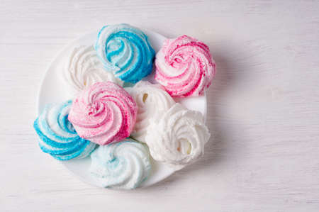 Homemade sweet colored meringue on white background. Dessert.