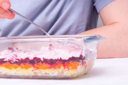 Step by step preparation of russian traditional new year appetizer - herring under layers of boiled vegetables and mayonnaise (shuba). step 8 of 11 - spread mayonnaise on layers of grated vegetablesの写真素材