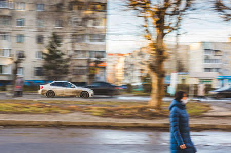 Cheboksary, Russia, November 08, 2020 :: Silver dirty car in motion on city streets with blurred background.のeditorial素材