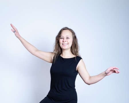 girl in a black dress and with natural make-up keeps balance and smilingの写真素材