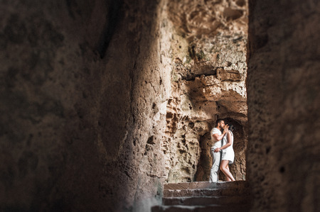 Couple in love kissing in a cave. Guy and girl kissing. The couple in the cave. A lonely loving couple. Man and womanの写真素材