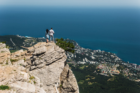 A couple in love travels. Boy and girl at the sea. Travelers. Man and woman have a rest abroad. The relationship between man and woman. Honeymoon trip. Newlyweds on their honeymoon. On the edgeの写真素材