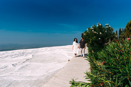 Man and woman traveling. Couple in love walking. Couple in Pamukkale. Traveling to Turkey. Lover. Honeymoon trip. Guy and girl are traveling. Tourist attractions. Newly married couple. Honeymoonの写真素材