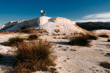 Admire the views of the hill Man and woman standing on the mountain. A couple in love travels. A couple in Turkey. Wedding travel. Honeymoon trip. Outdoor recreationの写真素材