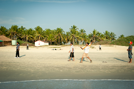 Friends play cricket on the beach of GOA in India. The guys play Indian baseball on the beach. Indian national sport. The game of cricket at sunsetのeditorial素材