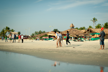 Friends play cricket on the beach of GOA in India. The guys play Indian baseball on the beach. Indian national sport. The game of cricket at sunsetのeditorial素材