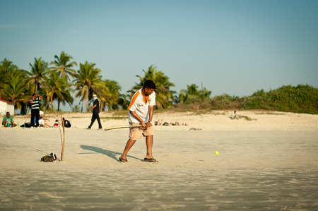 Friends play cricket on the beach of GOA in India. The guys play Indian baseball on the beach. Indian national sport. The game of cricket at sunsetのeditorial素材