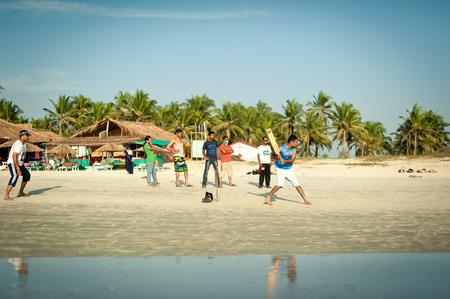 Friends play cricket on the beach of GOA in India. The guys play Indian baseball on the beach. Indian national sport. The game of cricket at sunsetのeditorial素材