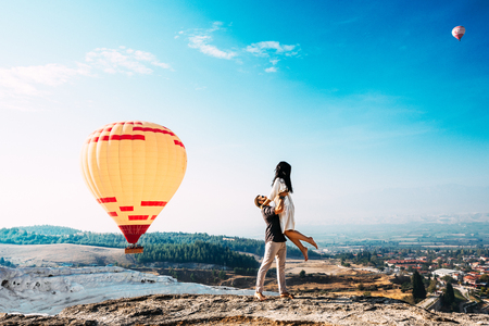 Couple in love among balloons. A guy proposes to a girl. Couple in love in Pamukkale. Couple in Turkey. Honeymoon in the mountains. Man and woman traveling. Flying on balloons. Wedding. Journey. Loveの写真素材