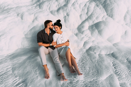 Loving couple in the arms. Man and woman hugging on white background. Stylish couple in love. Newly married couple. Romantic couple. A man hugs a woman. Lovers at sunset. Feelings between peopleの写真素材