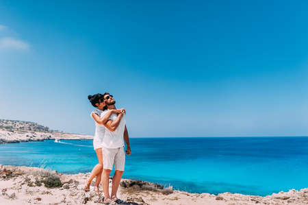 Happy couple by the sea. Man and woman hugging on the beach. Honeymoon lovers. Man and woman on the island. Couple in love on vacation. Sea tour. Honeymoon trip. Couple in love at the blue lagoonの写真素材