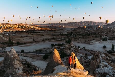 Man and woman greet the dawn among balloons. Couple in love among balloons.  Travelers in the mountains of Cappadocia, Turkey. Man and woman traveling. Flying on balloons. Festival of balloonsの写真素材