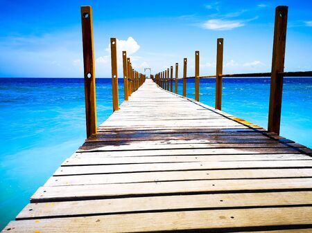 A photo of nature taken on a smartphone. Pier going into the blue sea. Beautiful boat dock in Bali....