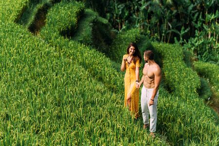A man and a woman among the rice terraces. A couple in love travels through Asia. Man and woman are traveling in Bali. Happy couple in Bali. The couple travels the world. Rice terraces in Bali.の写真素材