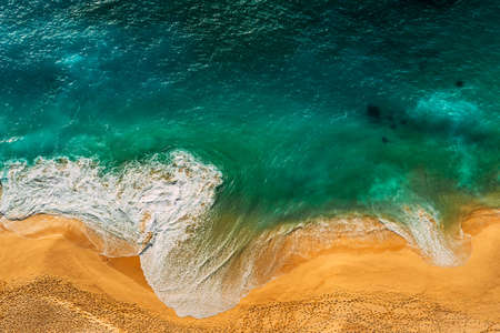 Seascape top view. Panoramic view of the sea waves. Foamy waves roll over the seashore. A vivid picture of marine nature. Stormy oceanic tide. Beaches of Indonesia. Sea foam. Copy spaceの写真素材