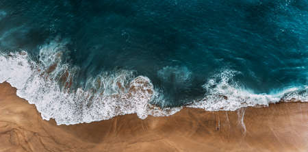 Panorama of a clean beach. Aerial view of the blue ocean waves on the beach. Beautiful sandy beach with blue sea. Lonely sandy beach with beautiful waves. Nusa penida. Copy spaceの写真素材