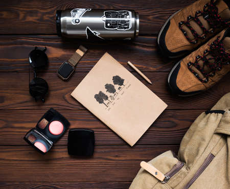 Backpack, sneakers, watch, Notepad on a wooden background. Women's travel accessories on a wooden background. Female traveler's kit.の写真素材