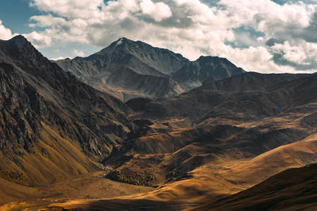 Incredibly beautiful mountain landscape. Mountain peaks in the sun. Panoramic view of the autumn mountains. Landscape with views of mountain valleys. Top view of the mountain gorge. Copy spaceの写真素材