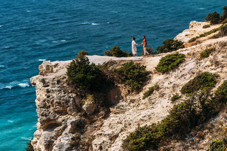 Man and woman at the sea. A couple in love travels. A couple in love spends a vacation at the sea. The relationship between a man and a woman. Honeymoon trip. Newlyweds on their honeymoon. Copy spaceの写真素材
