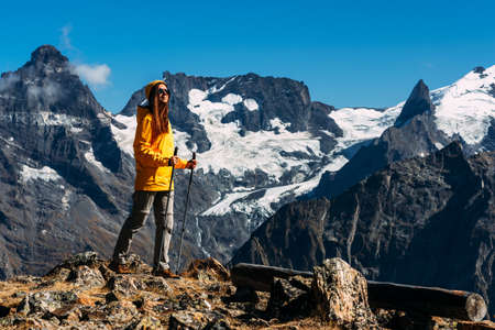 Hiking in the mountains. A person is engaged in Nordic walking in the Caucasus mountains. Girl climber on the way to the top of the mountain. Tourist in the Caucasus mountains. Copy spaceの写真素材