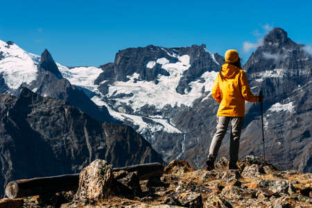 A woman traveling in the Caucasus. Mountain sports. Athlete happy finish. Mountain tourism. Walking tour. The journey to the mountains. Nordic walking among the mountains. Copy spaceの写真素材