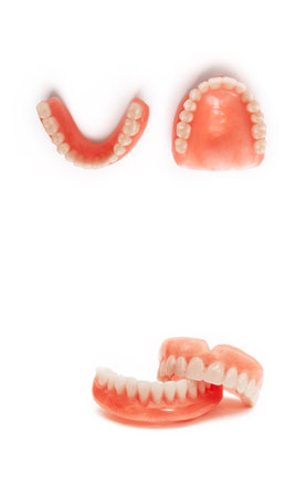 Dentures on a white background. Acrylic denture on white background. Full denture close-up. Full...