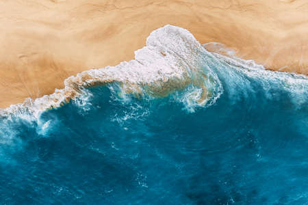 Blue ocean and clean sandy beach. Beautiful sea and wild beach with yellow sand. Blue ocean wave on a sandy beach. Top view of the tropical beach. Paradise island. Copy spaceの写真素材