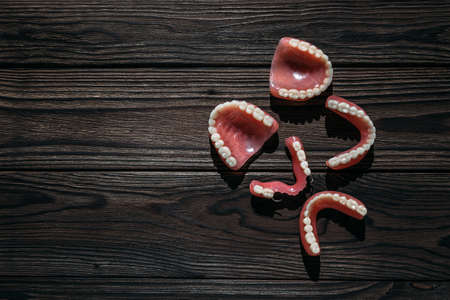 Dentures on a dark background. Close-up of dentures. Full removable plastic denture of the jaws....