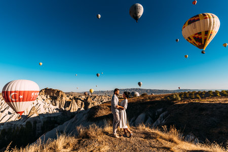 Early morning in Cappadocia, the flight of balloons. Couple travels the world. Honeymoon trip. Tourists in Cappadocia. A couple among balloons in Cappadociaの写真素材