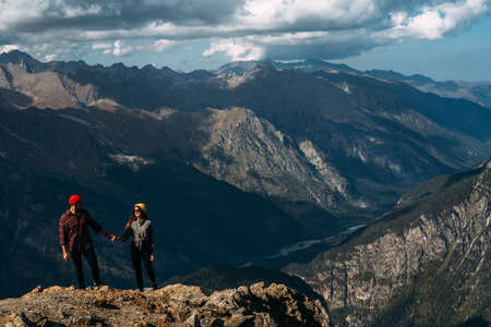 Couple in love in the mountains at sunset. Tourists on the tour. Couple in the Caucasus mountains, Russia. Man and woman at sunset. Tourists in the mountains, Dombay. Copy spaceの写真素材