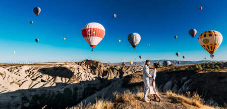 Turkey Cappadocia balloon flight, panorama. A beautiful couple on the background of balloons in Cappadocia. Travel to Turkey. Tourist places in Turkey. A wedding trip. Vacation in Turkey. Copy spaceの写真素材