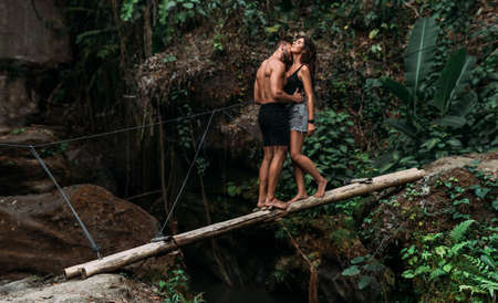A couple in love in the tropics. The couple is traveling in Indonesia. A beautiful couple is traveling on the island of Bali. A man and a woman kiss against the background of nature. Copy spaceの写真素材