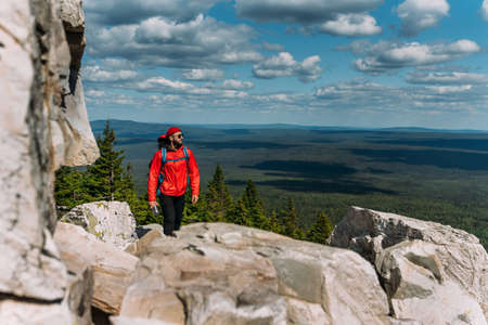 A traveler among the Rocky Mountains. A man is a traveler with a backpack among the rocks....