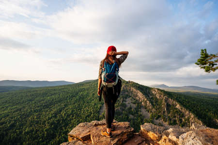 Traveler on the background of the mountain, rear view. A woman is traveling in Bashkiria, Russia. Mountain tourism in Russia. Walking tour of the mountains of Bashkiria, Aigir. Copy spaceの写真素材