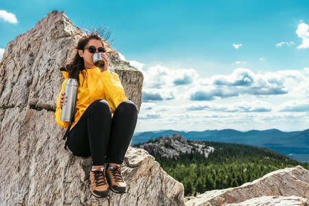 A female tourist is resting after a hard climb up the mountain. Copy spaceの写真素材
