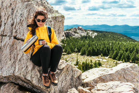A female tourist is resting after a hard climb up the mountain. Copy spaceの写真素材